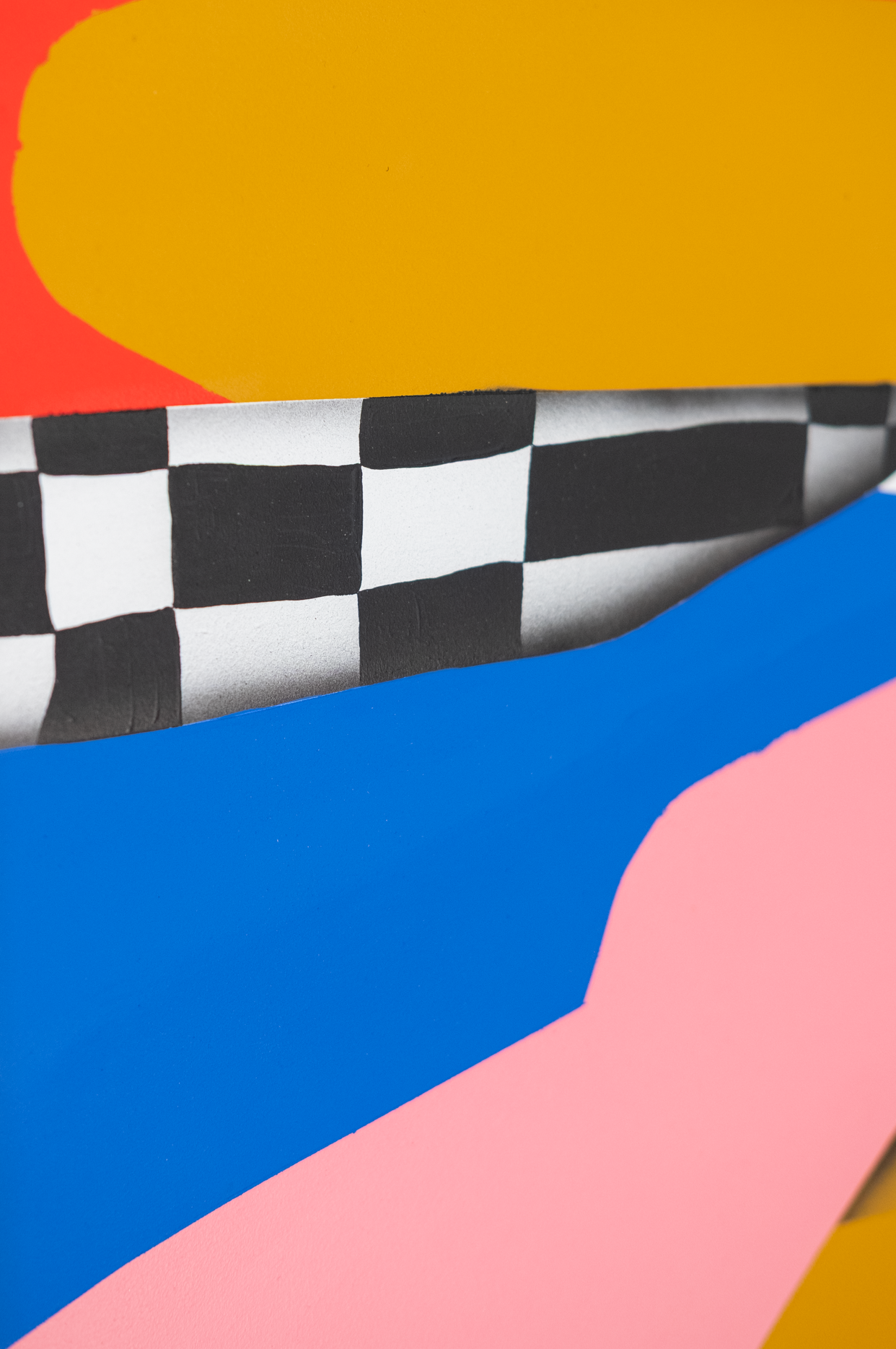 Abstract art piece with geometric shapes in red, yellow, black, white, blue, and pink on a wooden frame.
