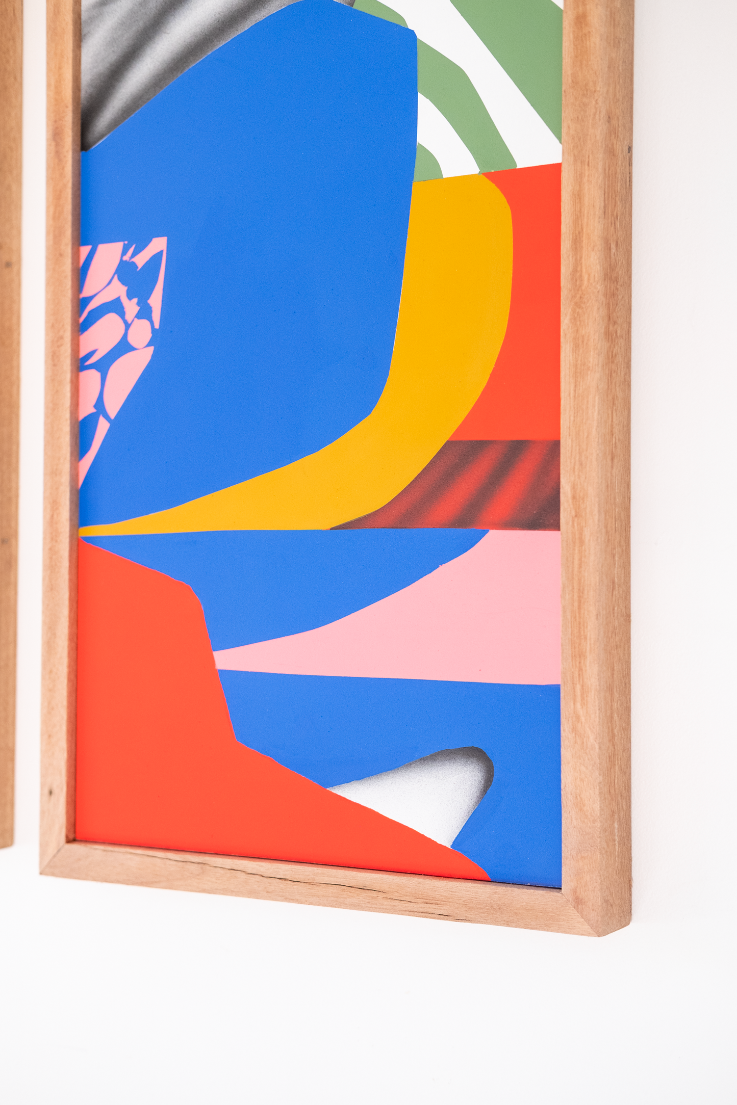 Colorful abstract art piece in a wooden frame on a white background