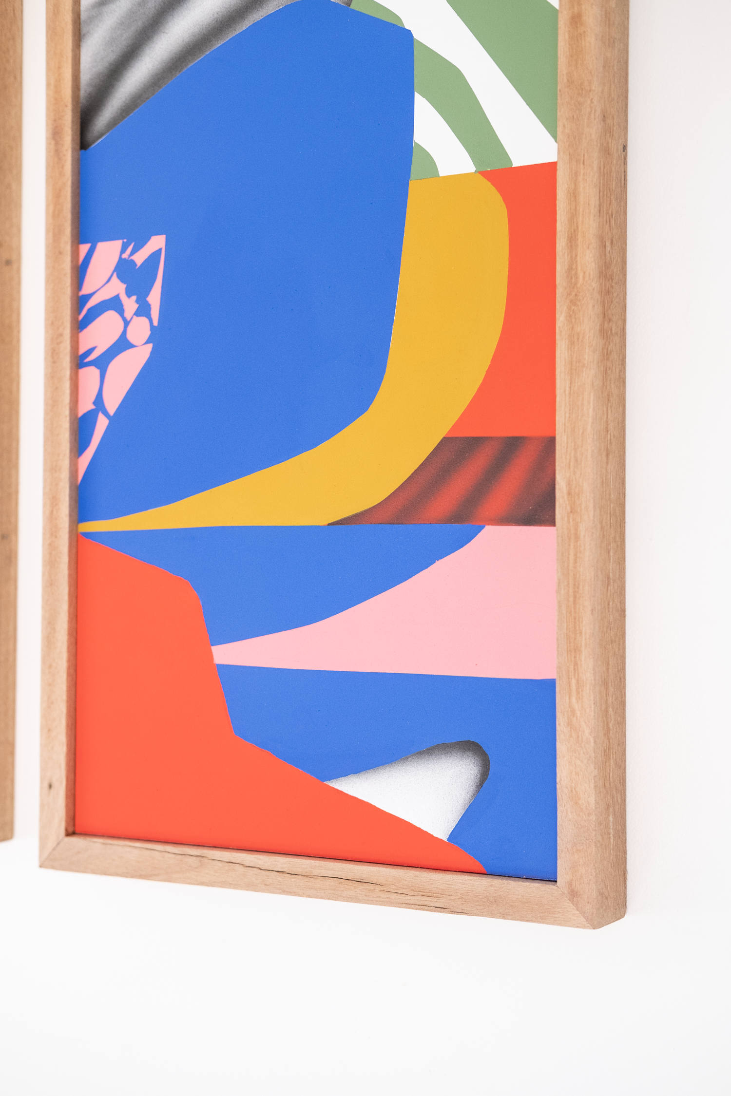 Colorful abstract art piece in a wooden frame on a white background